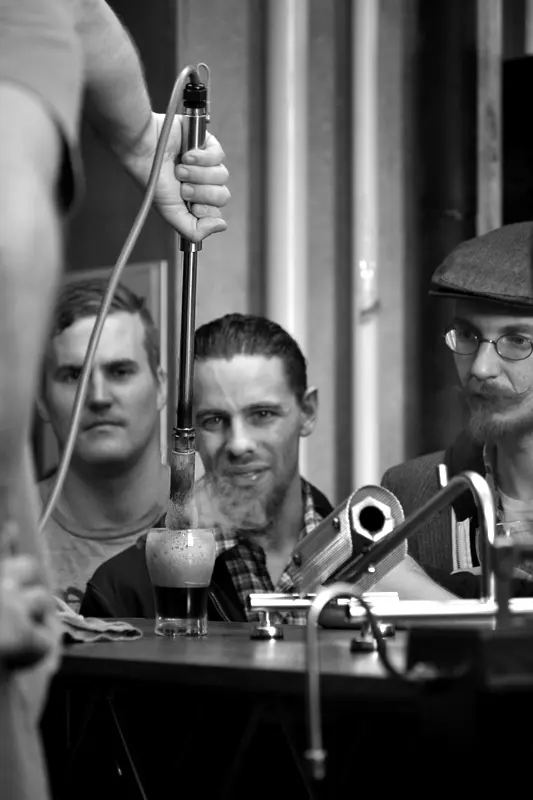 Onlookers watch a Garage Project beer poked by a hot poker