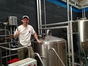 Wayward brewer Peter Phillip standing on a brewhouse