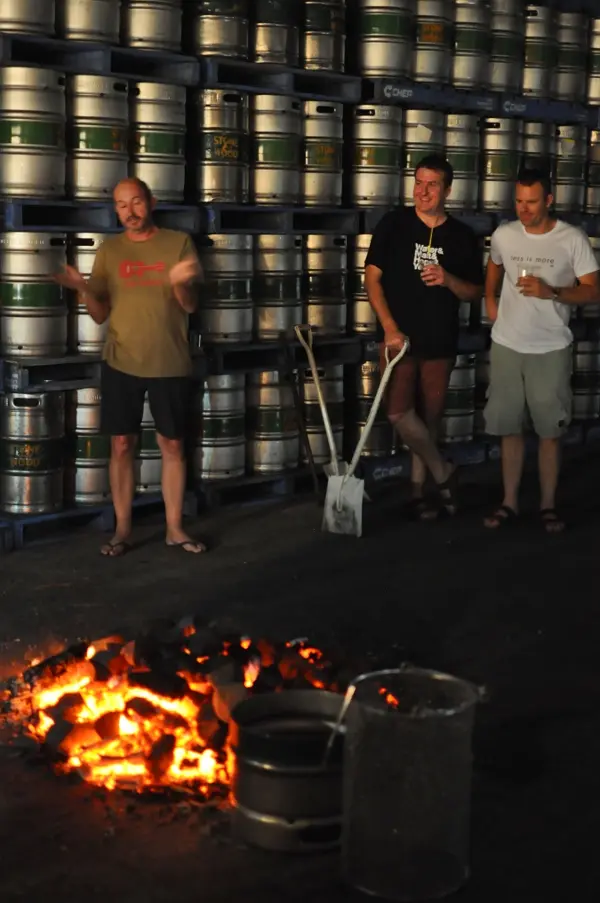 Brewery owners, Jamie, Brad and Ross, standing in front of the fire of rocks.