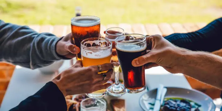 People holding beer glasses in a toast