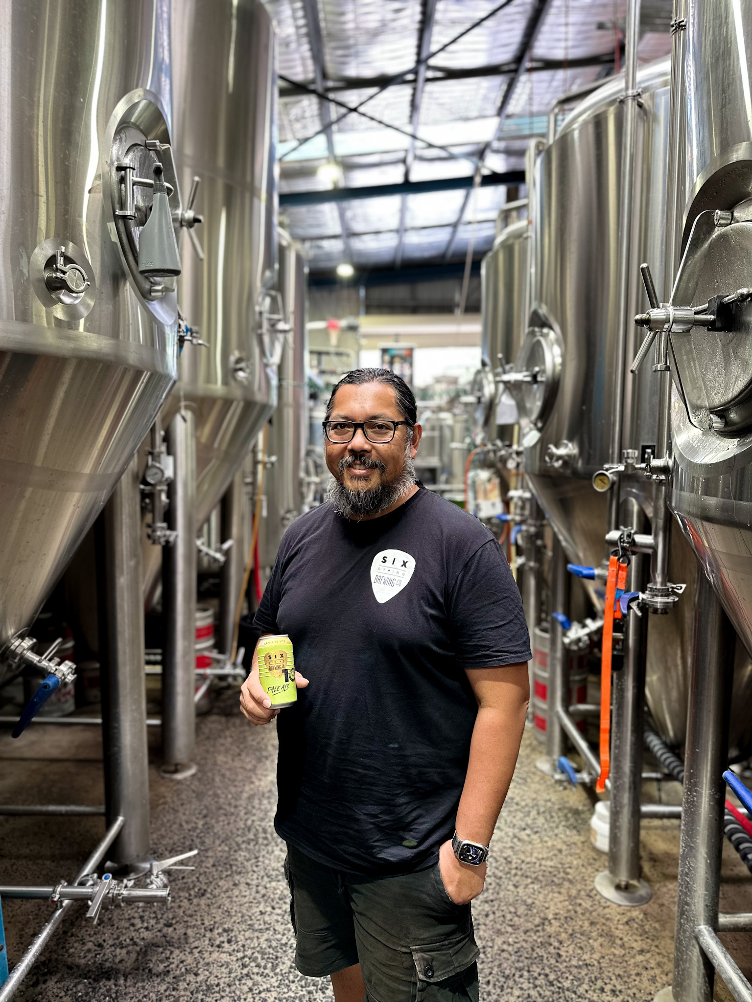 Man in a brewery holding a beer