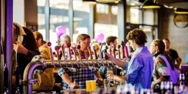 Bartenders serving beers to customers