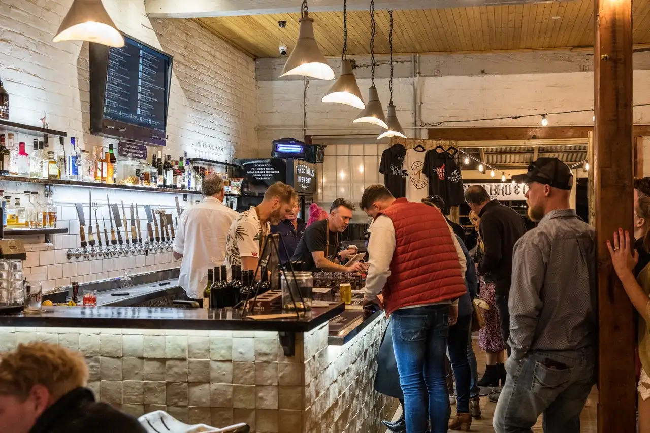 The bar at Three Tails Brewery with customers