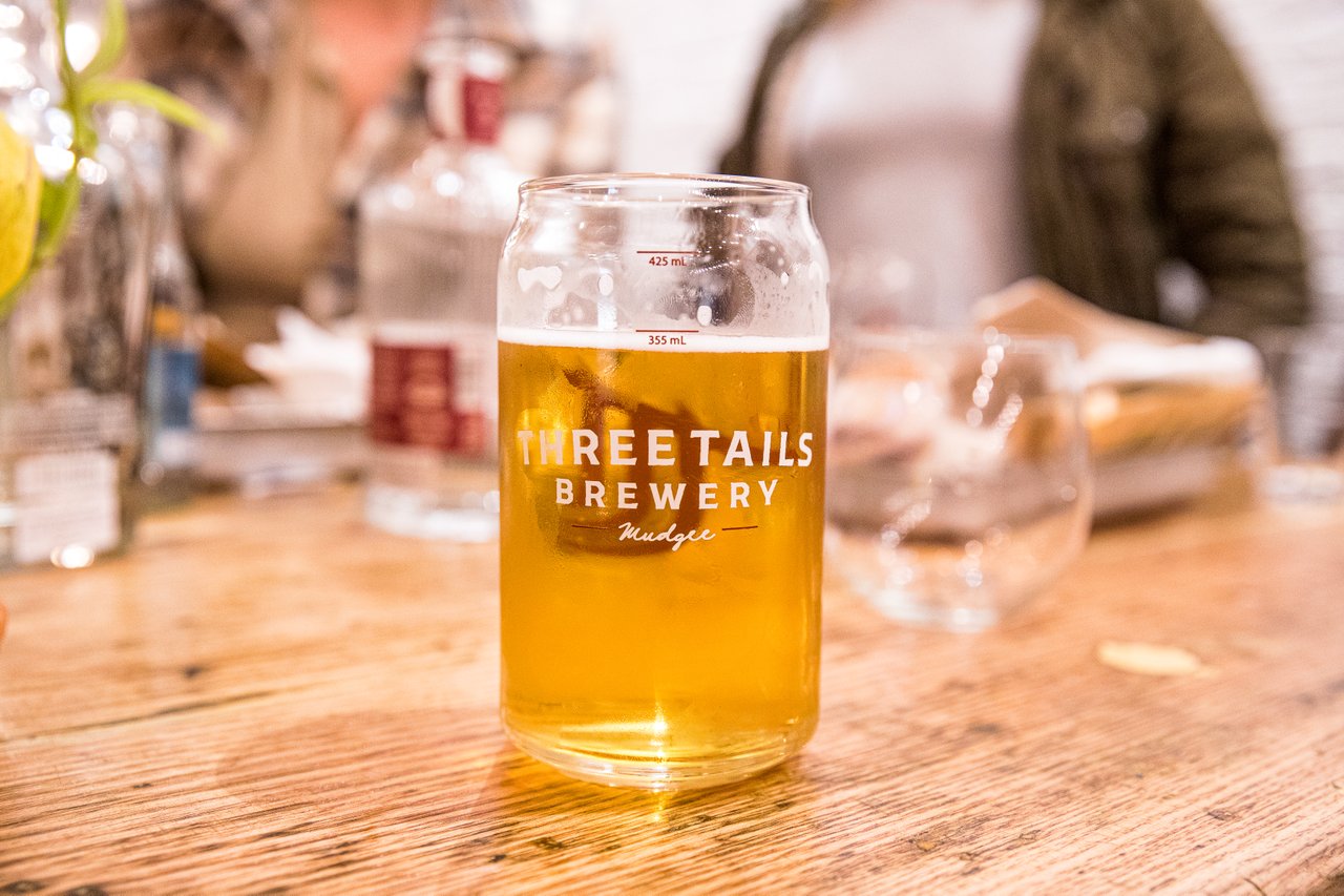 A glass of Three Tails' beer on a table