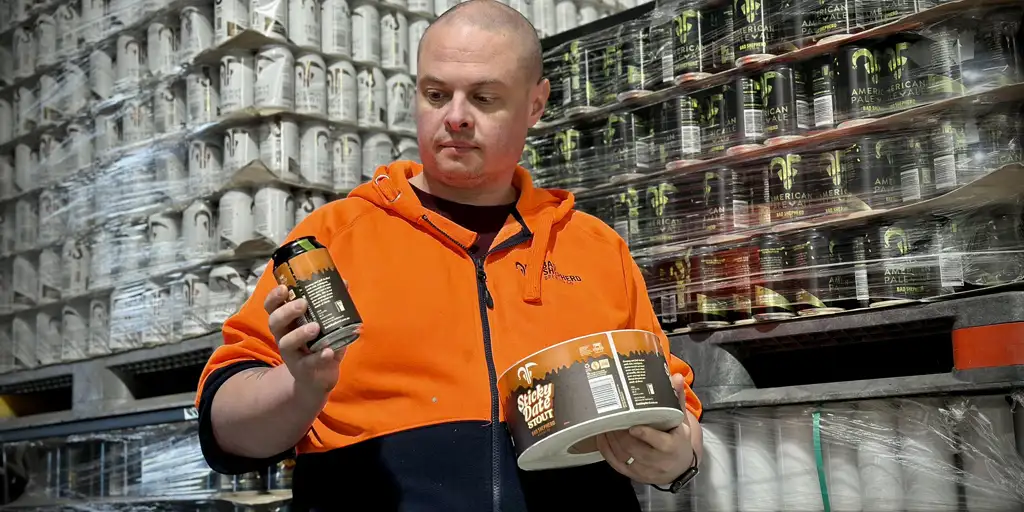 Bad Shepherd employee holding overlabelled can