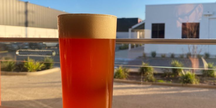 Glass of beer in front of Yellow Matter Brewing venue