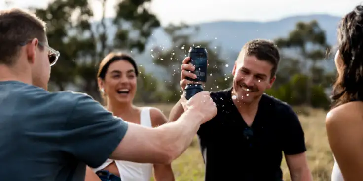 People toasting beer cans
